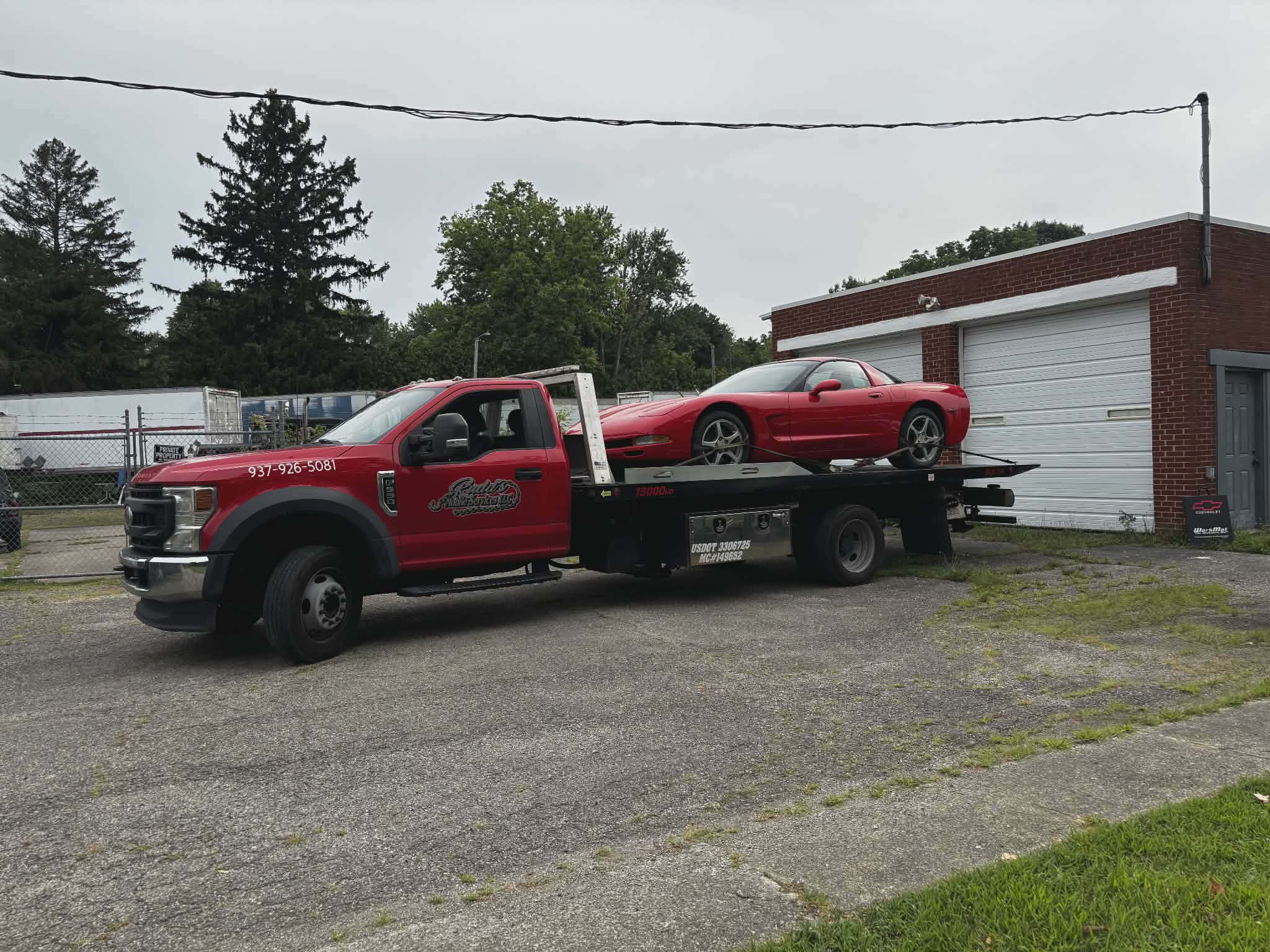 Rudd's red flatbed tow truck carrying a red Corvette